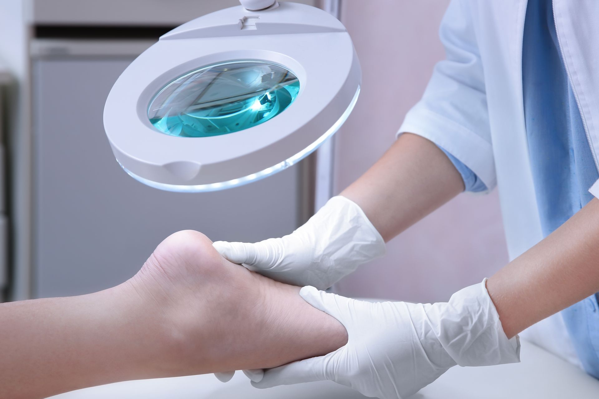 a healthcare professional wearing white gloves examining a patient's heel