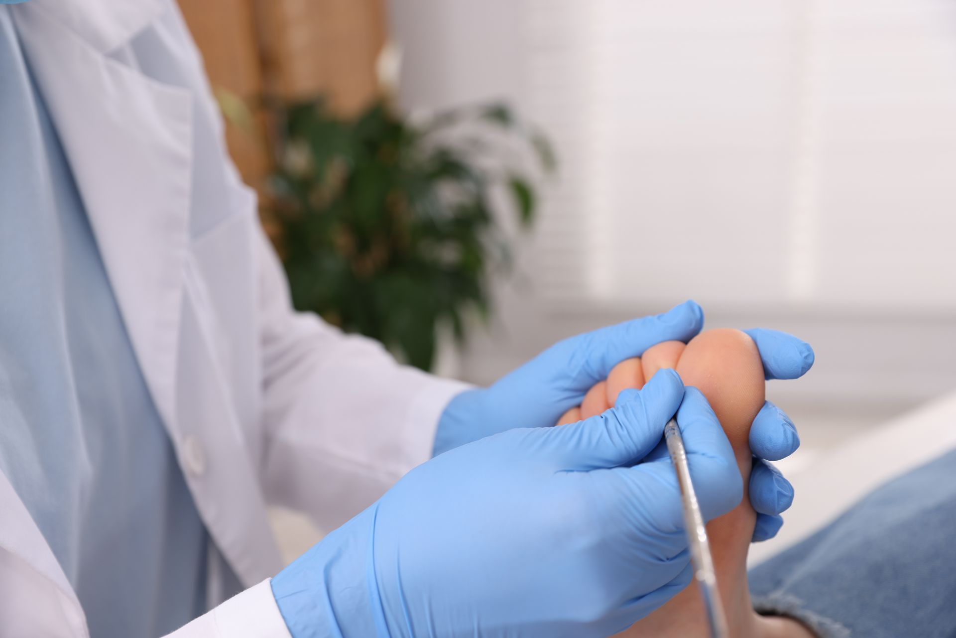 Podiatrist examining a patient's foot during a foot and ankle care appointment.