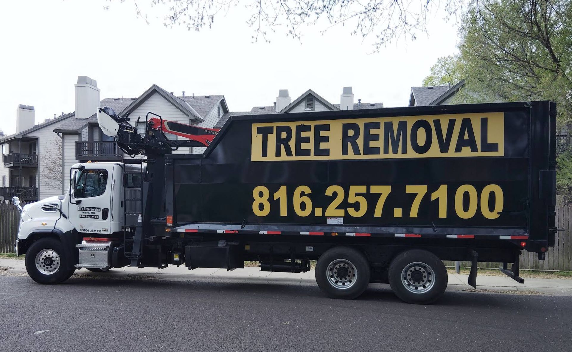A tree removal truck is parked on the side of the road