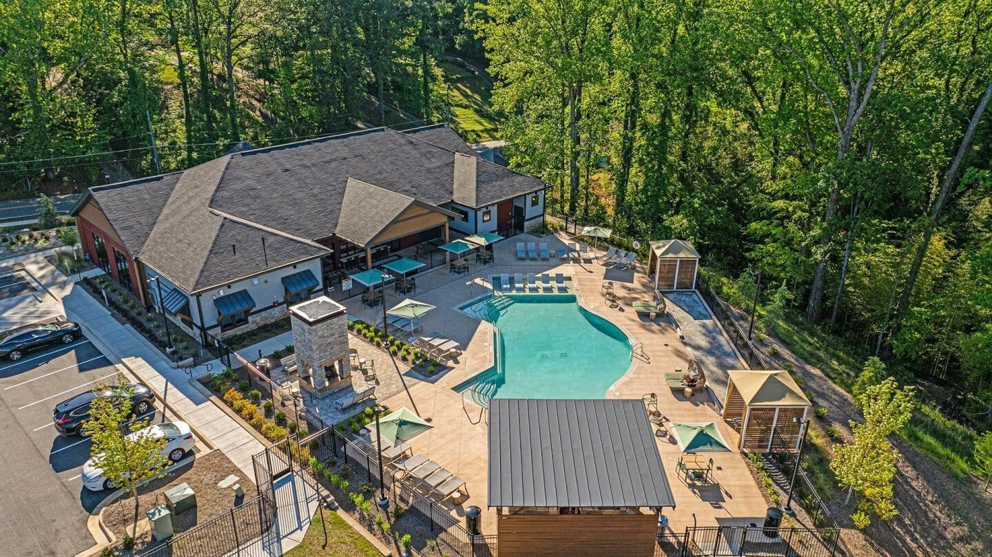 An aerial view of a large swimming pool surrounded by trees.