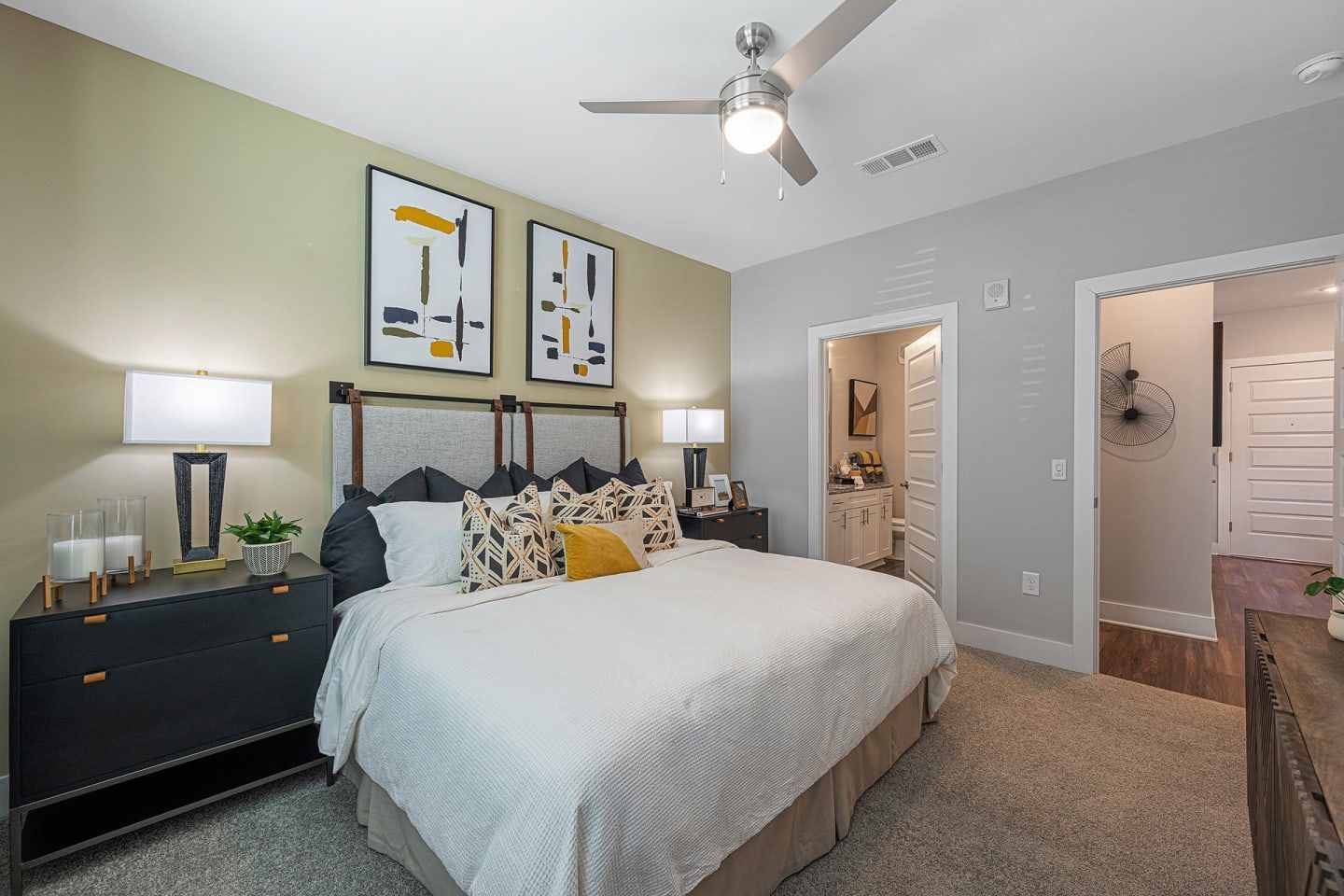 A bedroom with a large bed and a ceiling fan