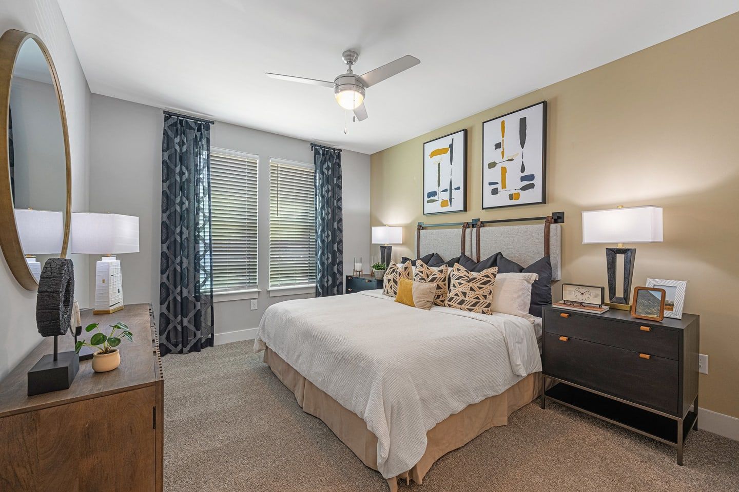 A bedroom with a large bed and a ceiling fan