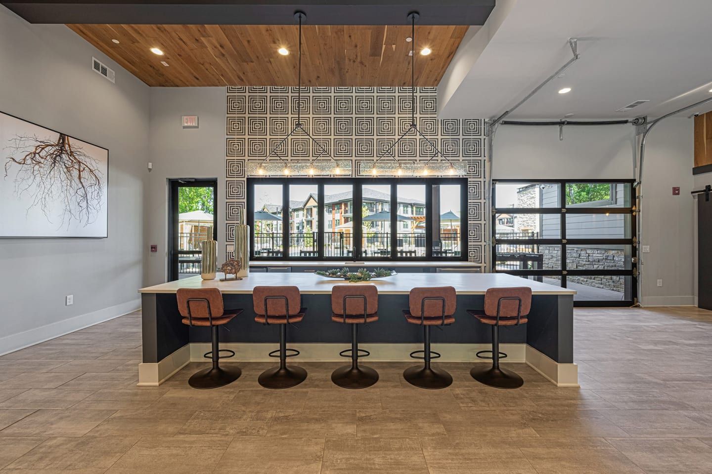 A large room with a bar and chairs in it