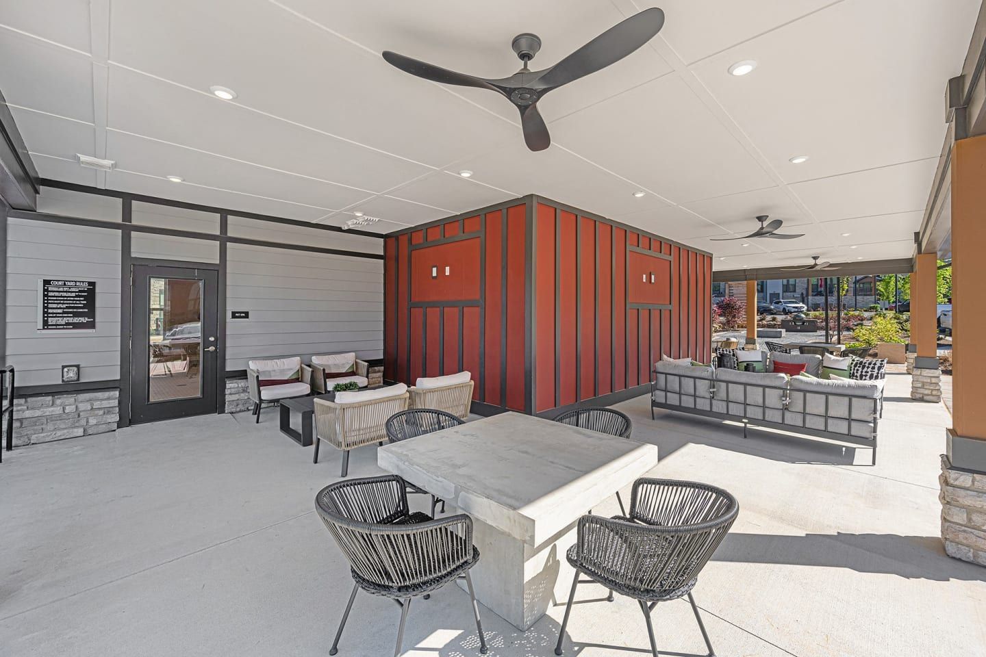 A patio with a table and chairs and a ceiling fan