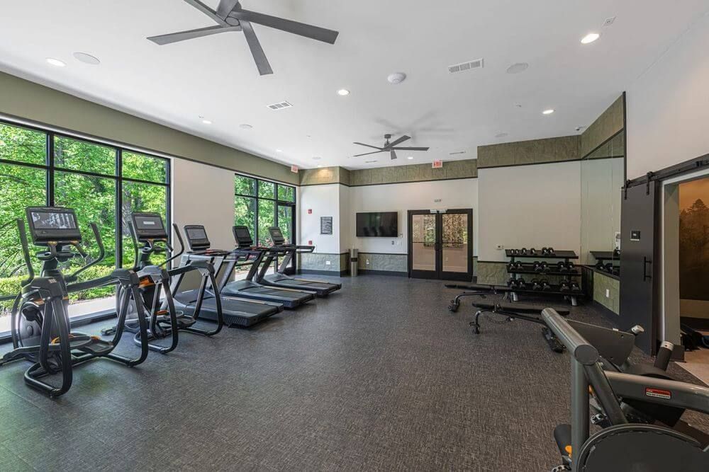 A gym with a lot of treadmills and exercise bikes
