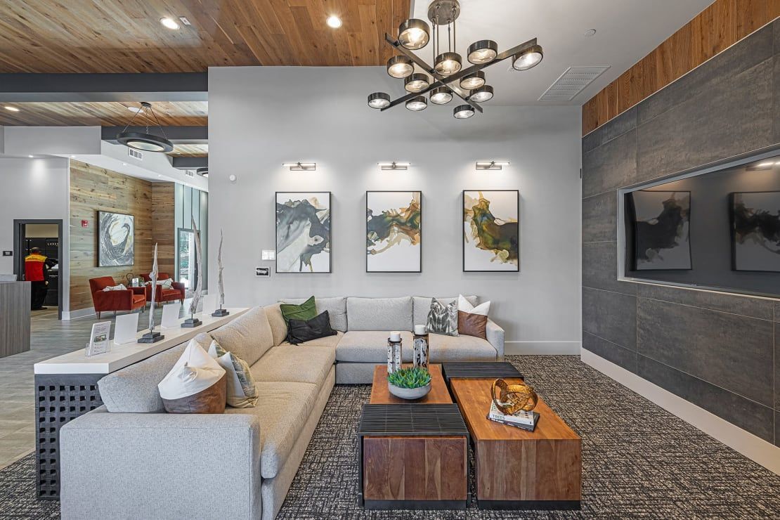 A living room with a large sectional couch and two coffee tables