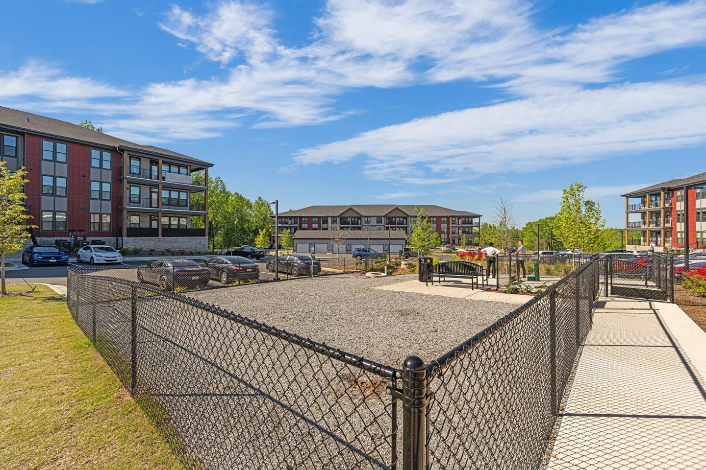 A chain link fence surrounds a gravel area in front of a building