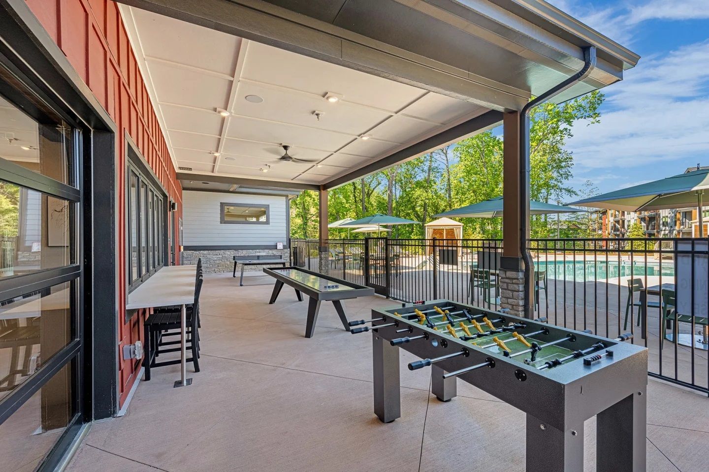 A covered patio with tables and a foosball table