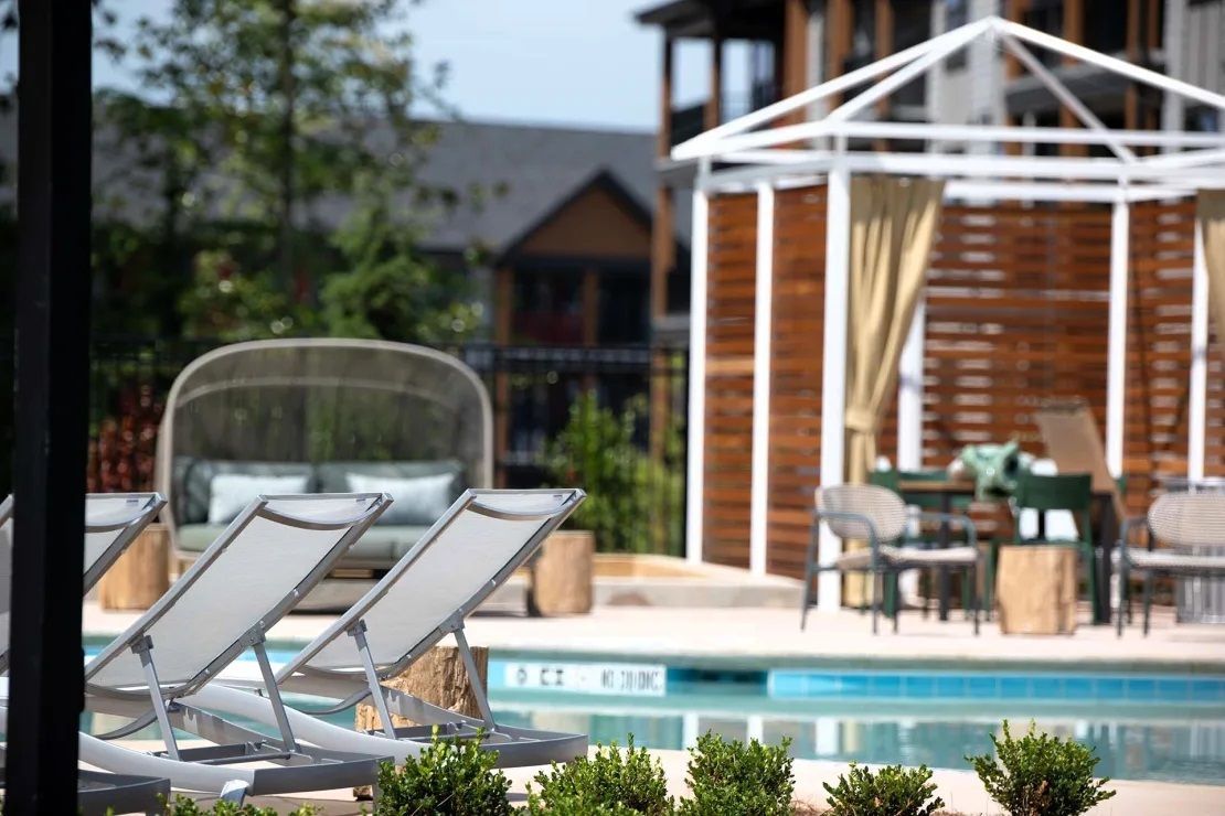 A large swimming pool with a gazebo in the background