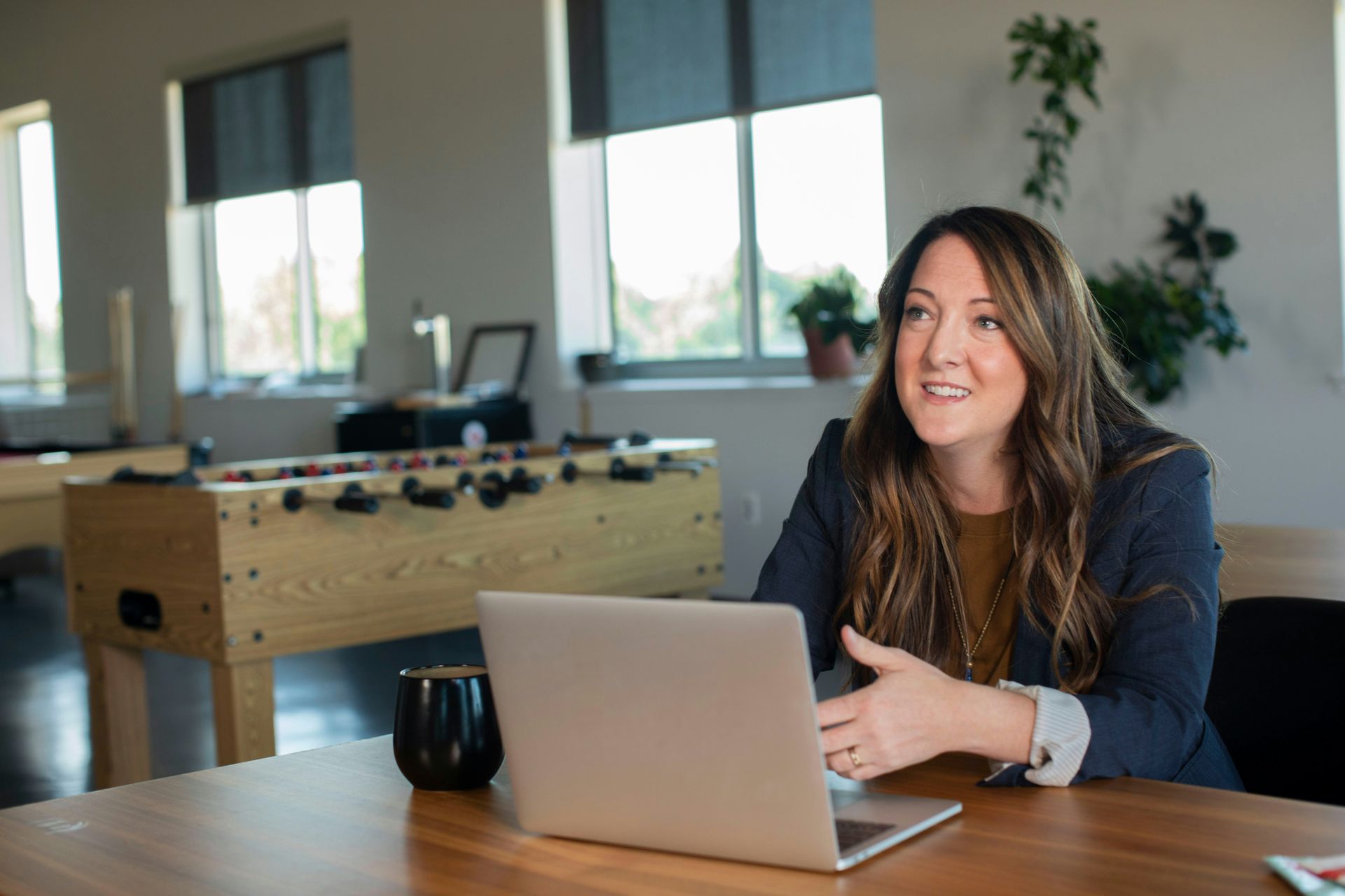 A woman is sitting at a table with a laptop computer.