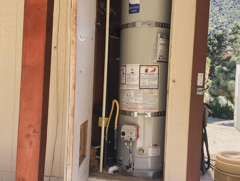 Person inspecting a water heater with pipes and expansion tank in a utility room