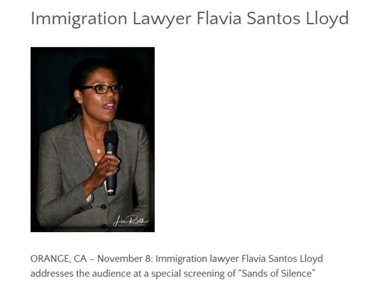Flavia Santos Lloyd speaking into a microphone at a screening of 