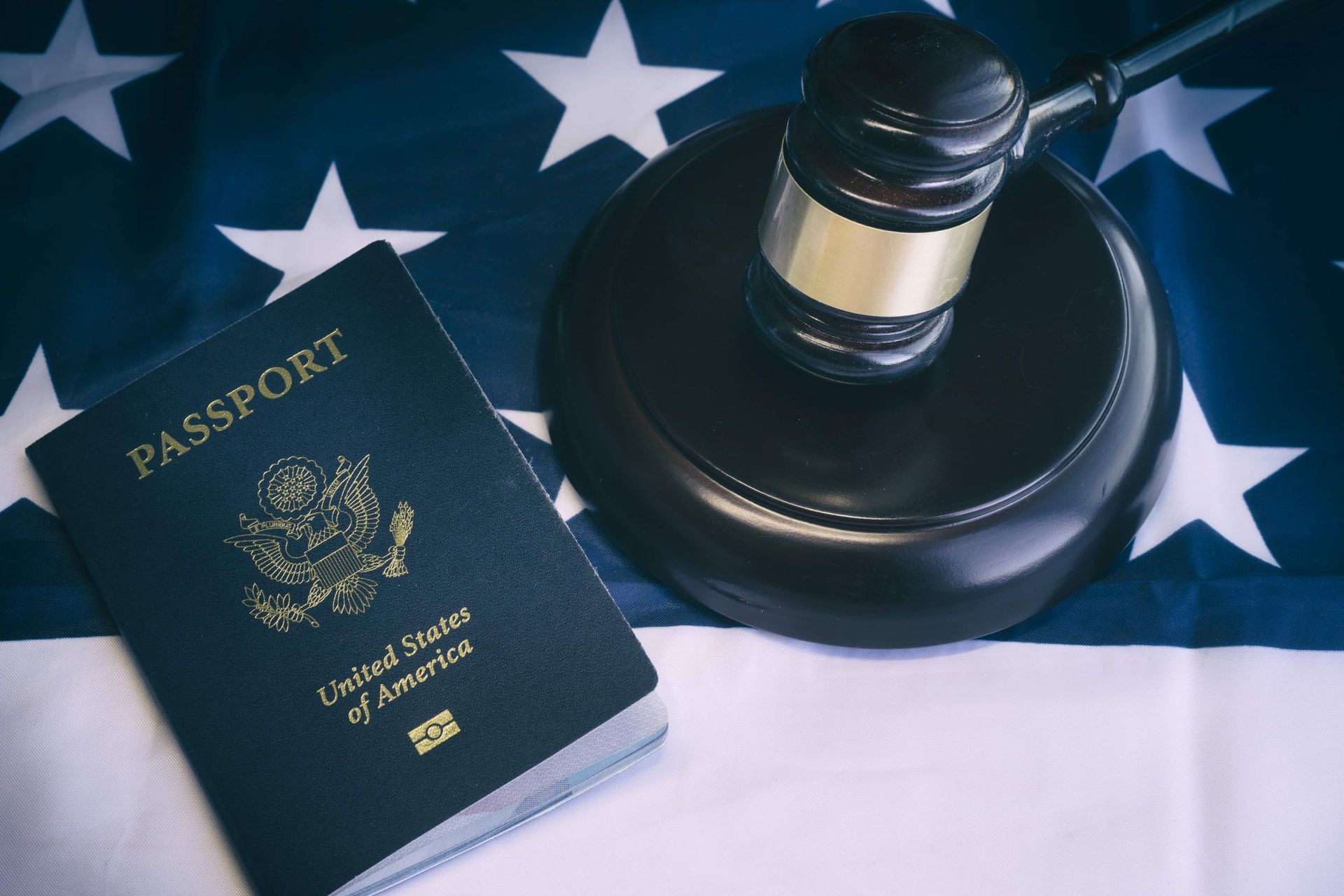Passport and gavel on an American flag, symbolizing legal and citizenship aspects.