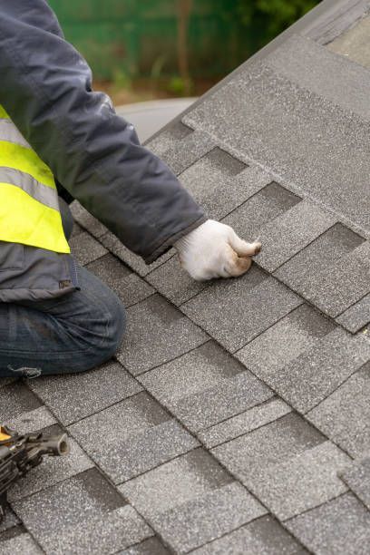 A man in a safety vest and yellow gloves works on a roof in WI, representing Link's Contracting, Inc