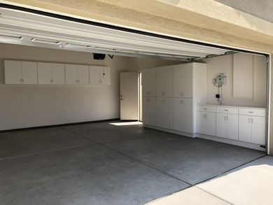 An empty garage with white cabinets and a clock on the wall