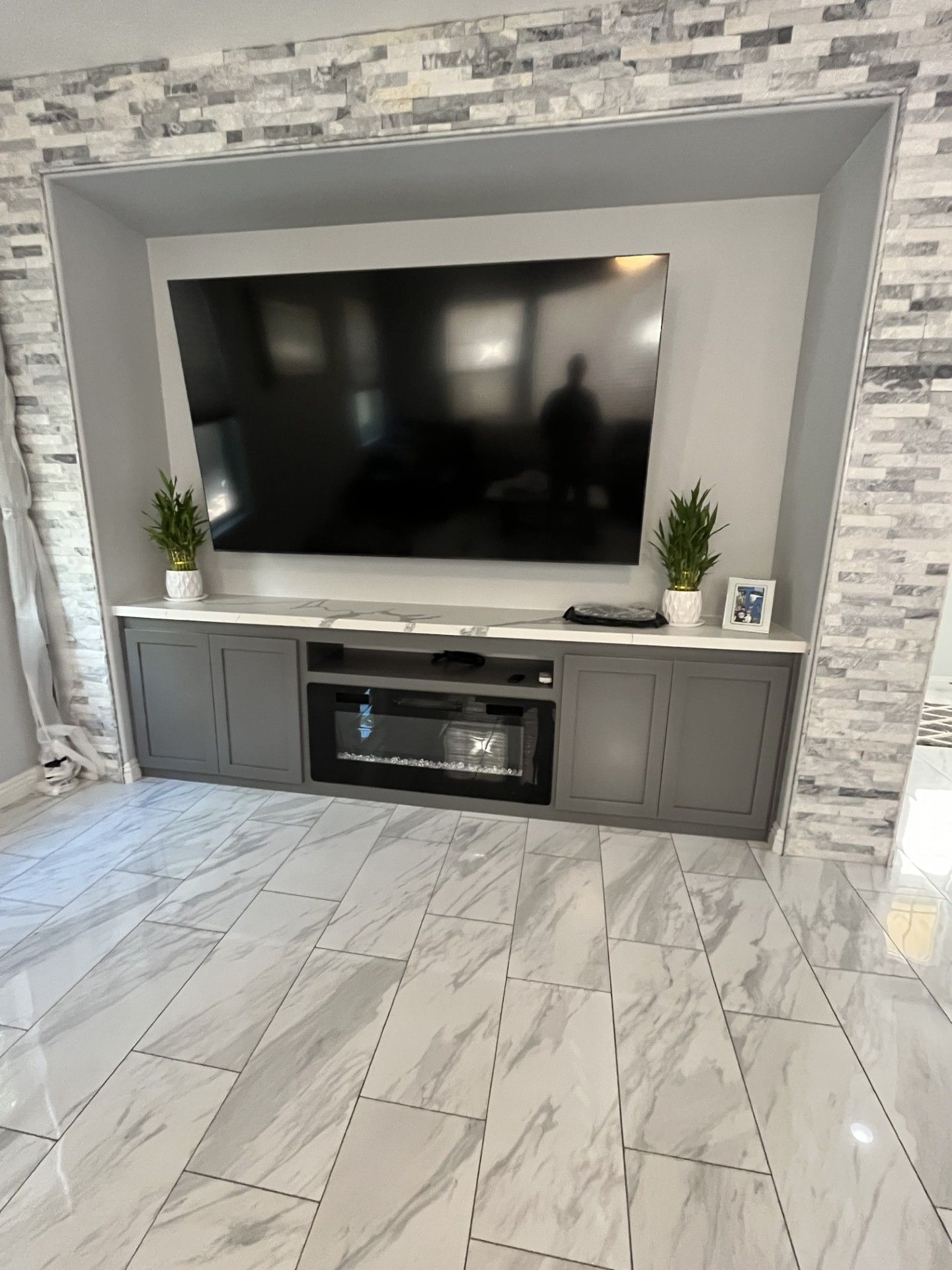 A living room with a flat screen tv and a fireplace.