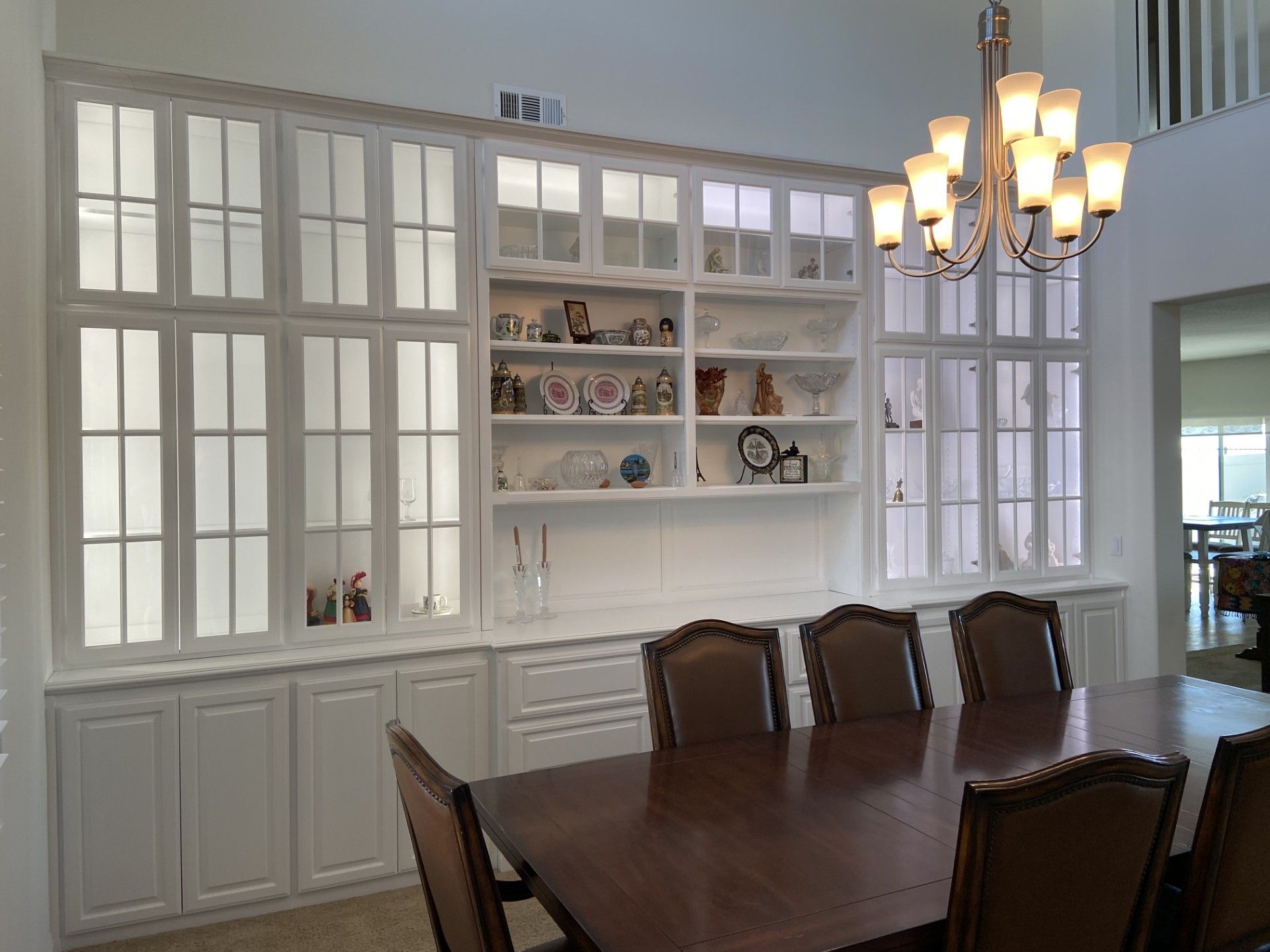 A dining room with a table and chairs and a chandelier.