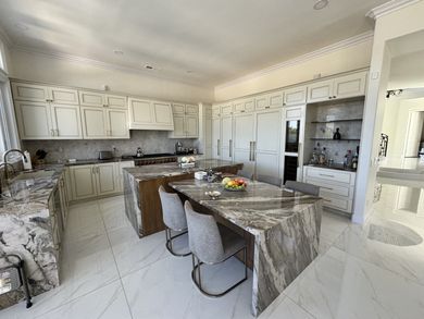 A kitchen with a large island and a table with chairs in it.
