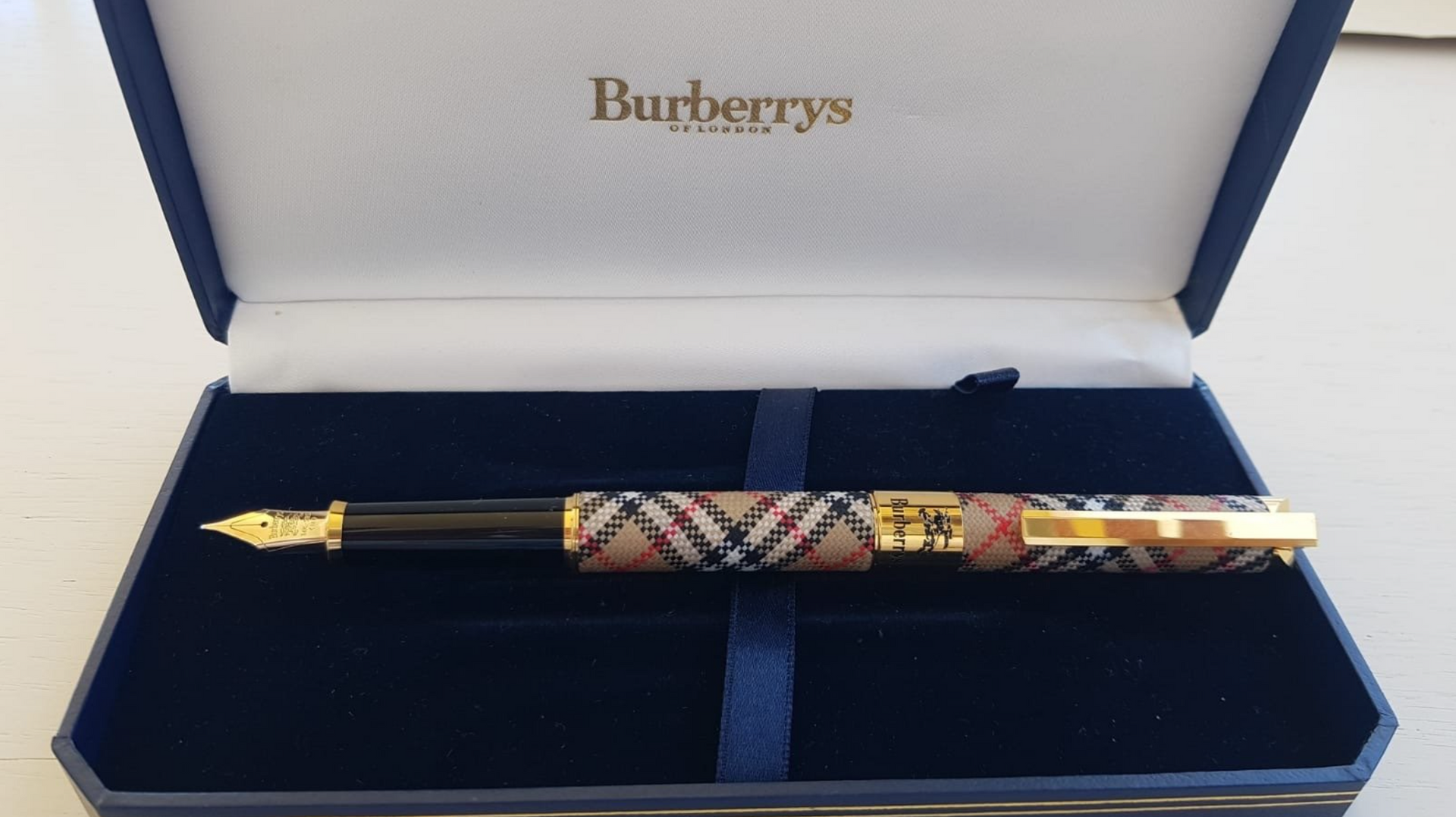 Burberry pen in a blue presentation box with patterned barrel and gold accents