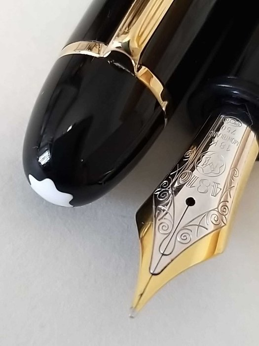 Black and gold fountain pen with a decorative nib on a white background
