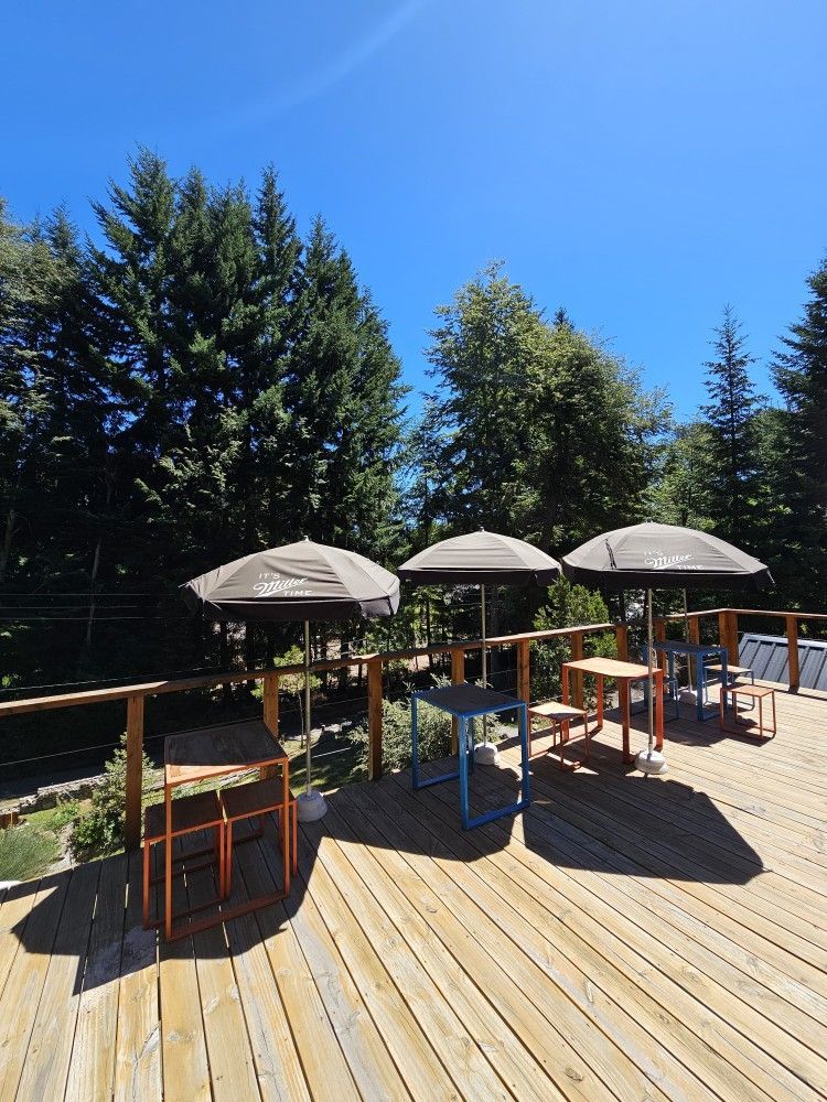 A wooden deck with tables and chairs and umbrellas