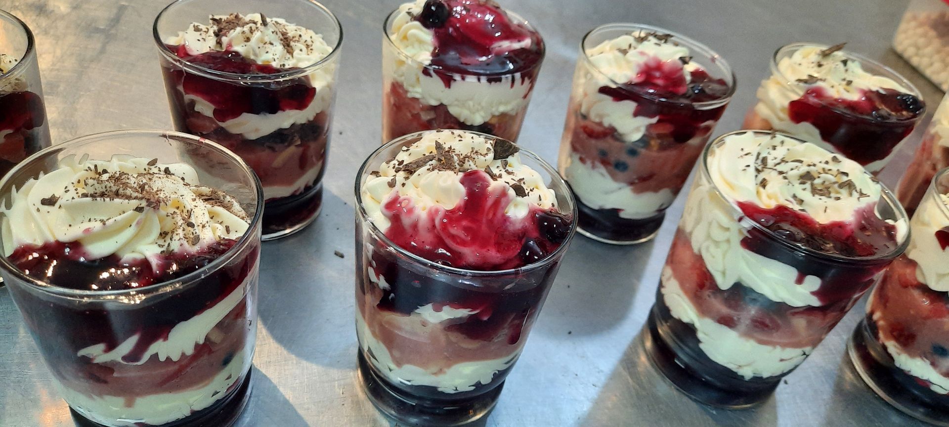 A table topped with bowls of food and jars of jam.