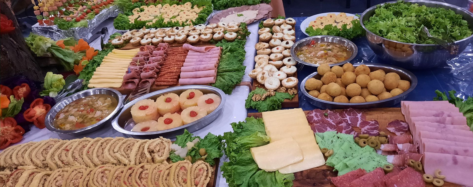 A table topped with plates , tongs , jars of jam and bread.