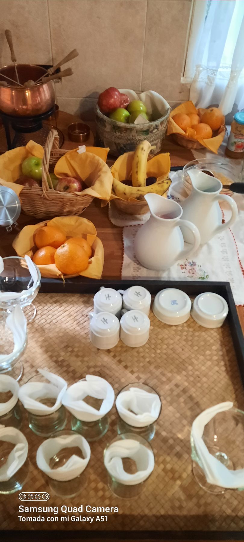 A table topped with bowls of fruit and candles.