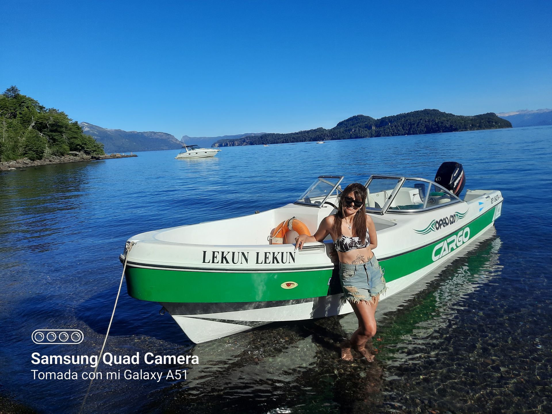 A woman is standing next to a boat in the water.