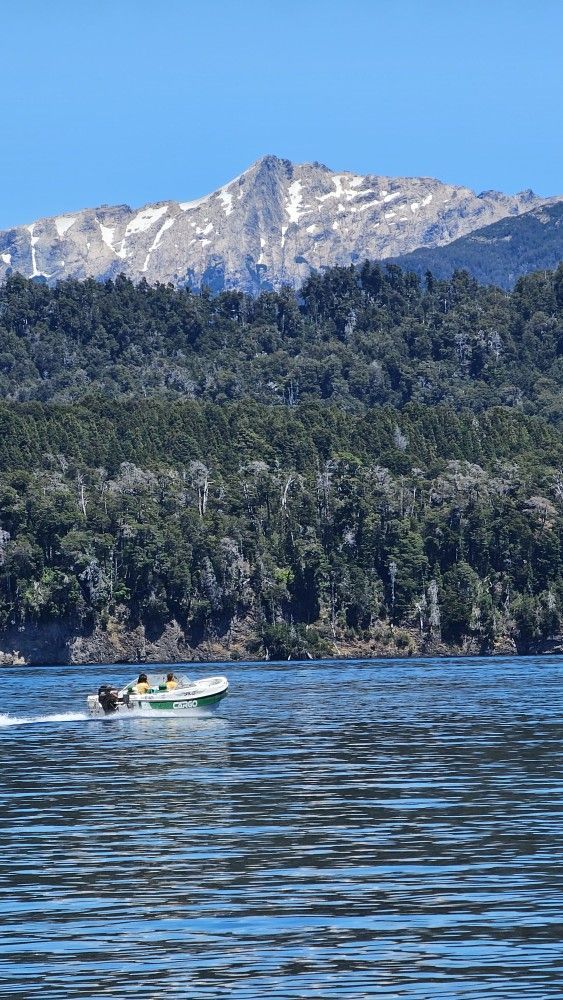 A boat is floating on a lake with mountains in the background.