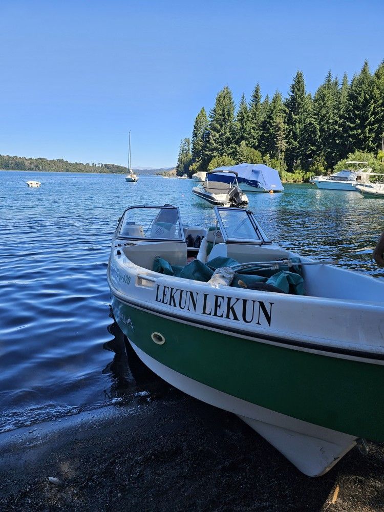 A green and white boat with the name lekun on it