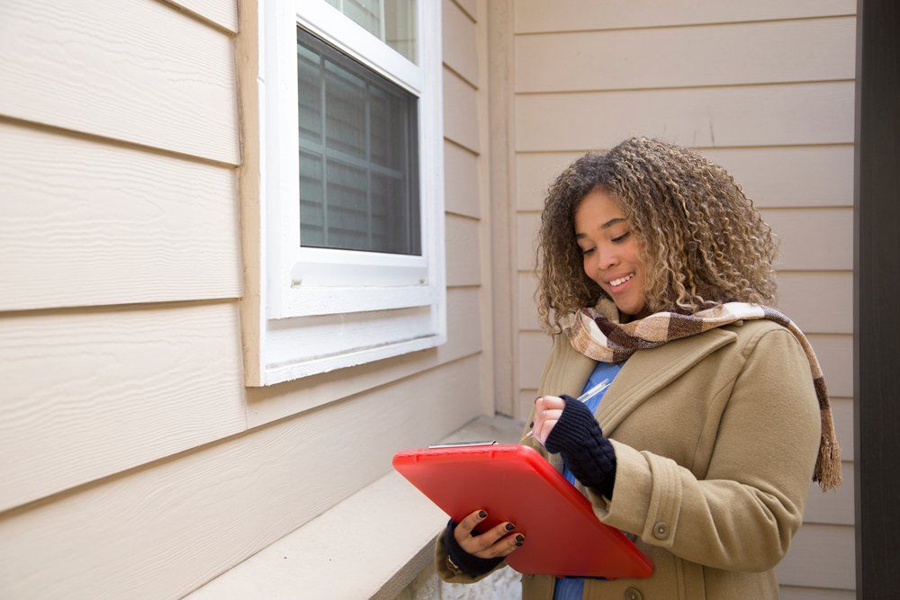 Woman Appraising A House — Minneapolis, MN — Appraisal Specialists Midwest Woman Appraising A House — Minneapolis, MN — Appraisal Specialists Midwest
