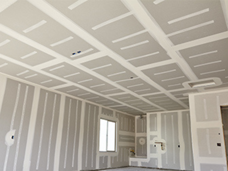A room with newly installed drywall prepped for painting.