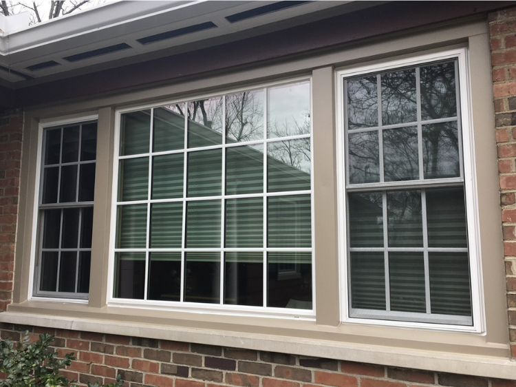 A brick house with three new windows.