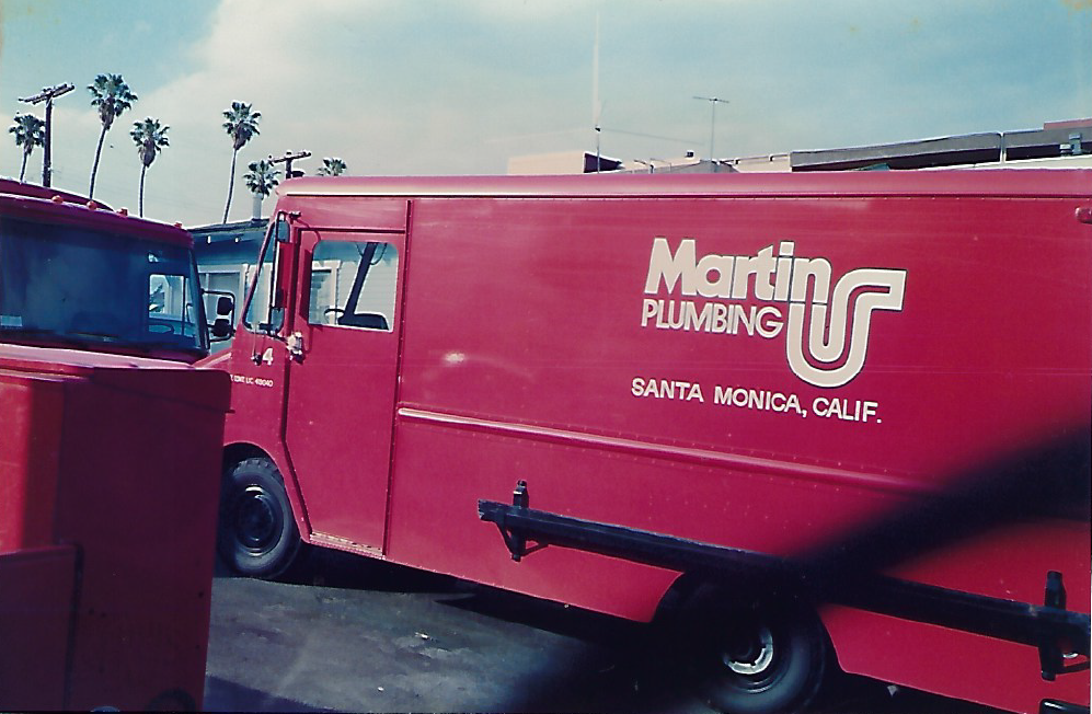 Red Martin Plumbing van in Santa Monica, California with palm trees in the background.