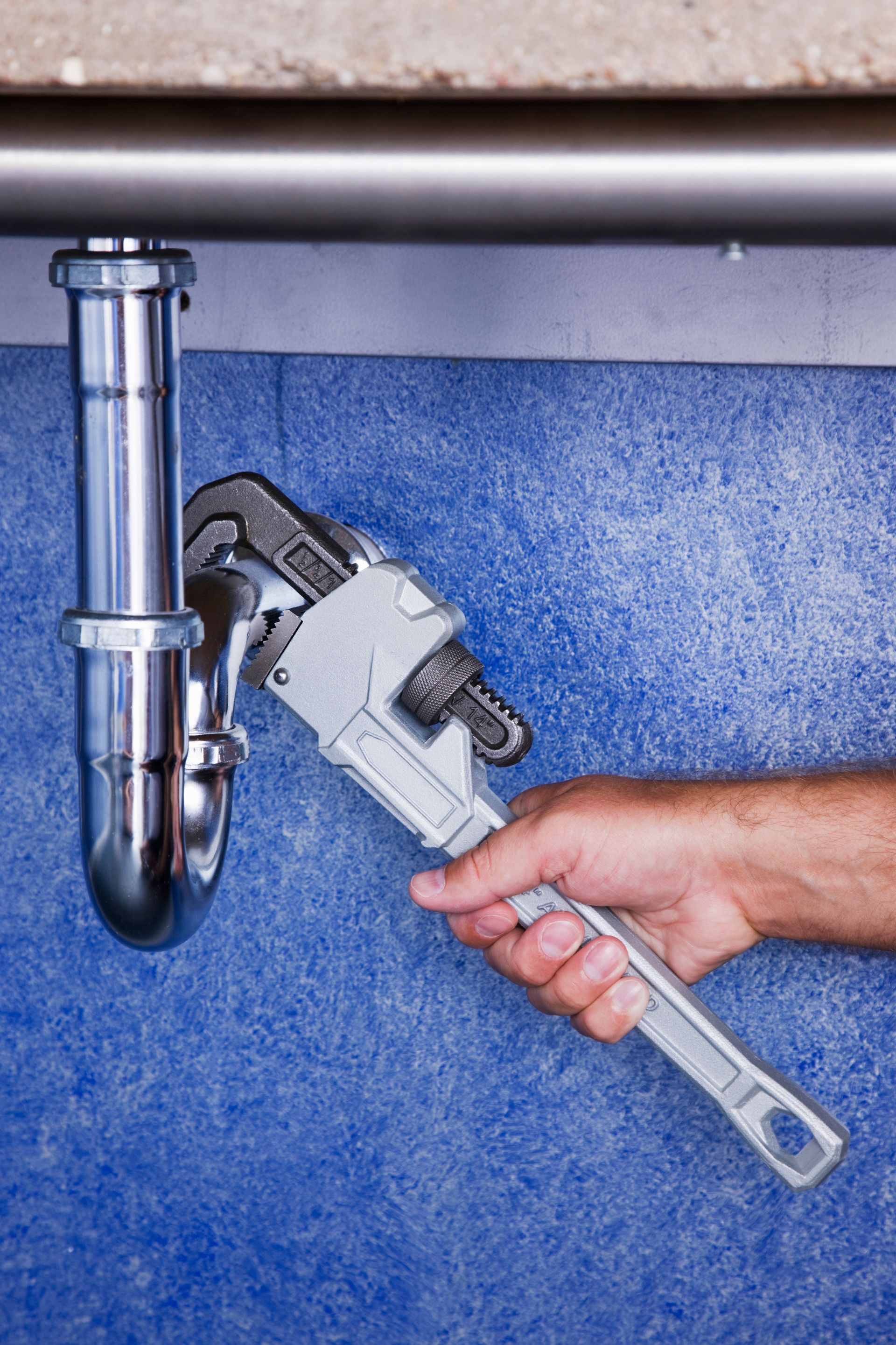 A person holding a wrench under a sink, representing Complete Plumbing's expert plumbing services in Springboro, OH. A person holding a wrench under a sink, representing Complete Plumbing's expert plumbing services in Springboro, OH.