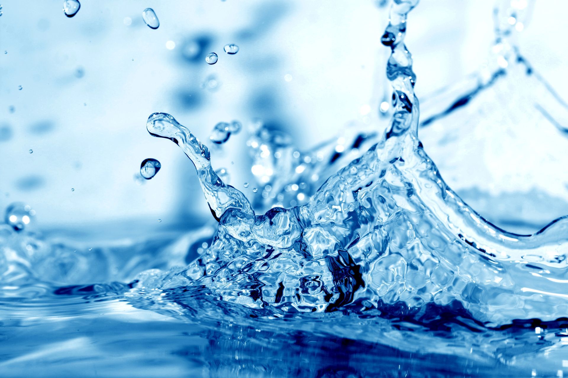A close up of a splash of water on a blue surface