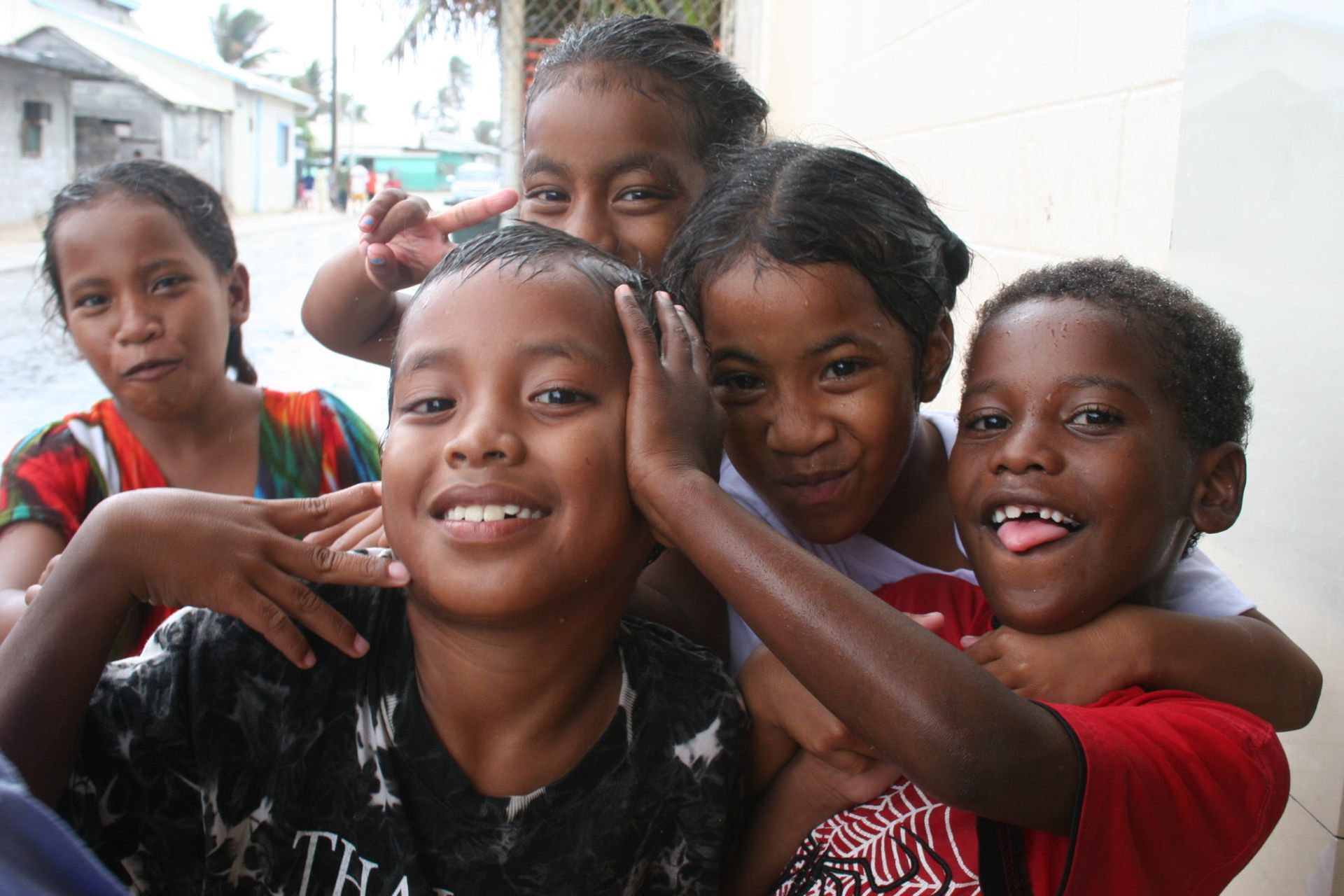 A group of island children happily posing for a picture to express their joy at Canvasback's Super Team arrival.
