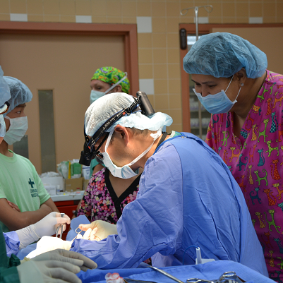 A group of surgeons are performing surgery in an operating room