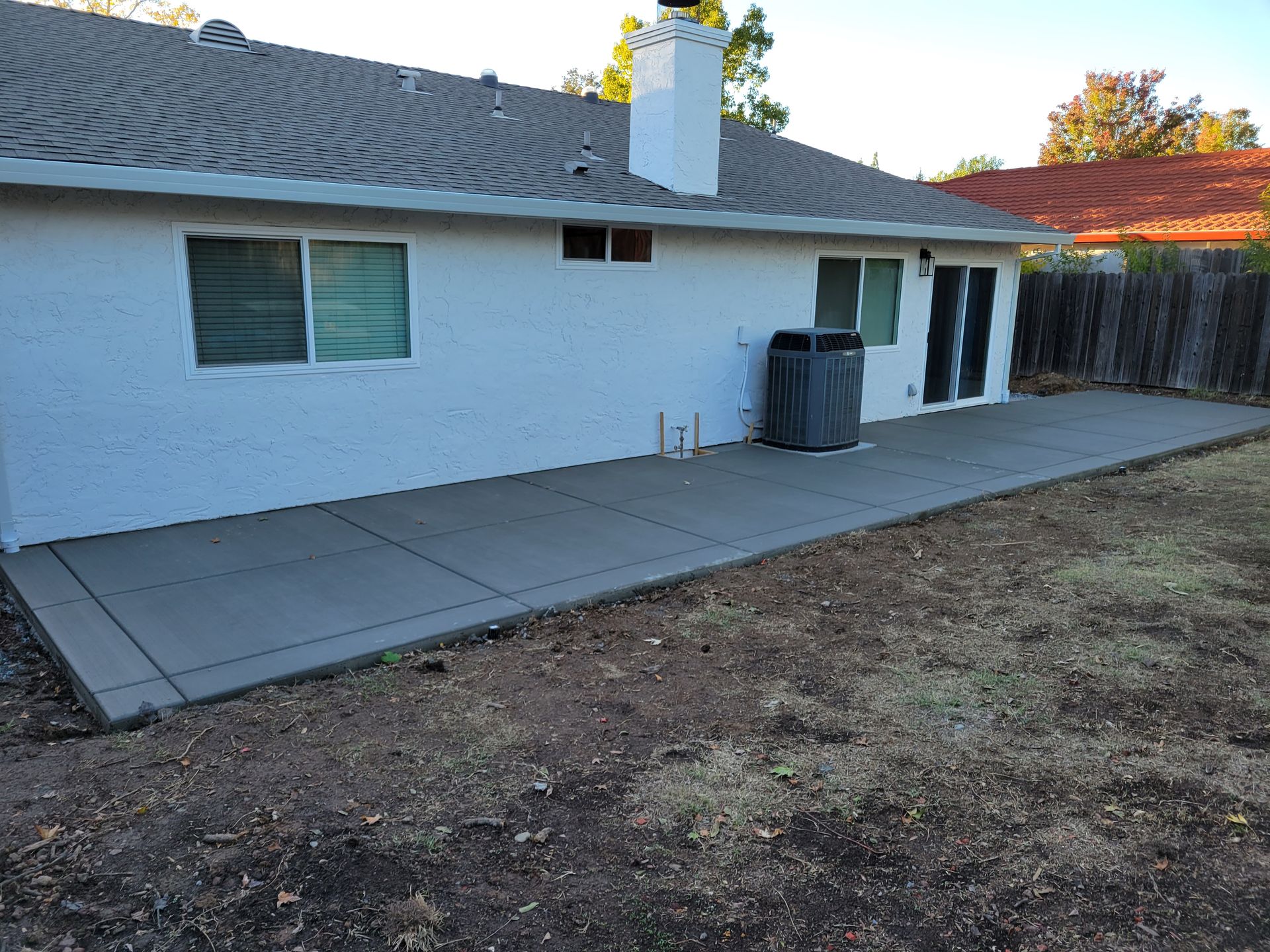 A white house with a concrete patio in front of it