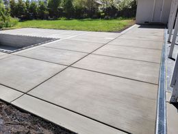 A concrete driveway is being built in a backyard.