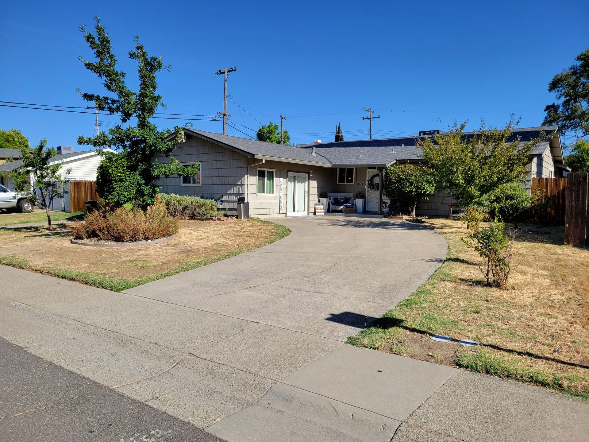 A house with a driveway and a fence in front of it