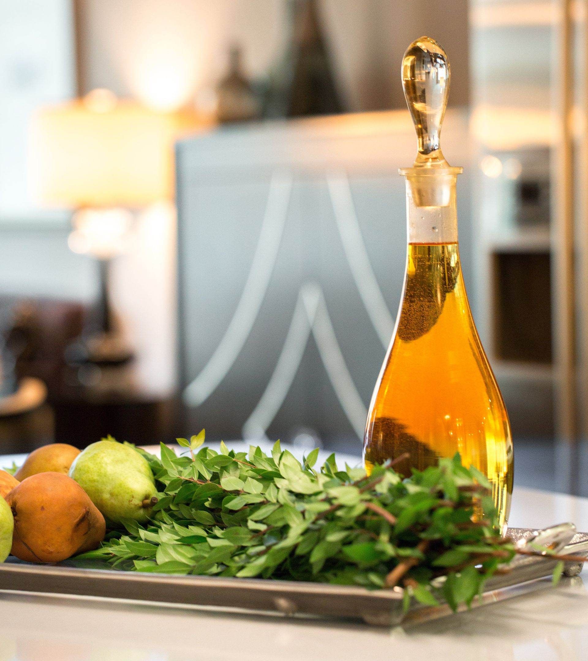 A bottle of wine sits on a tray of fruit and vegetables