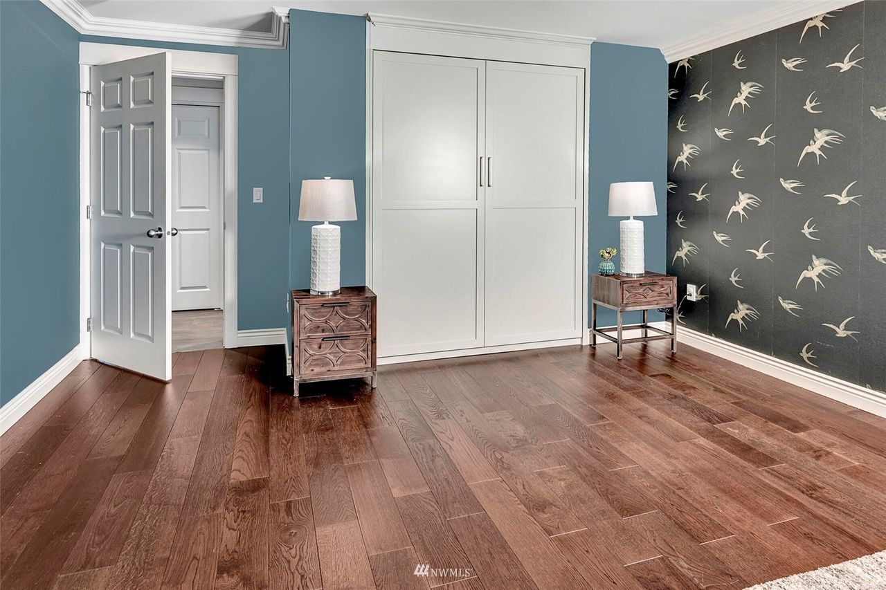 A bedroom with hardwood floors and blue walls