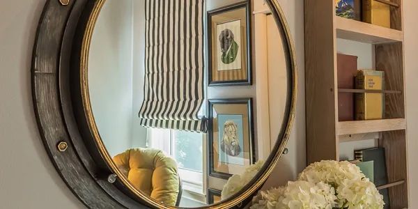 A round mirror is hanging on a wall in a living room.