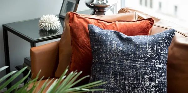 A couch with two pillows on it in a living room.