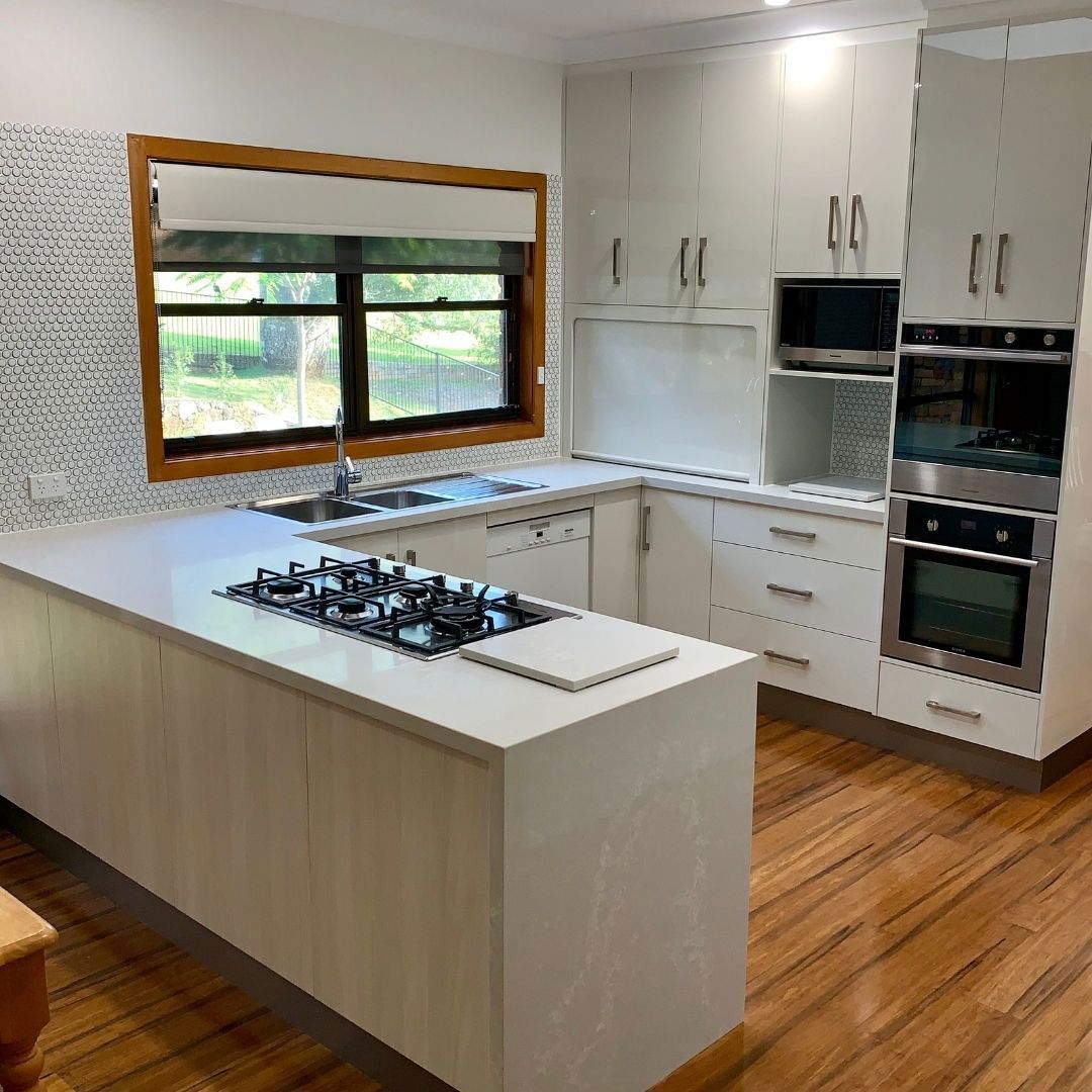 A Kitchen With White Cabinets, A Stove Top Oven, A Sink, And A Window — Ben Lynch Cabinetmaking in South Lismore, NSW