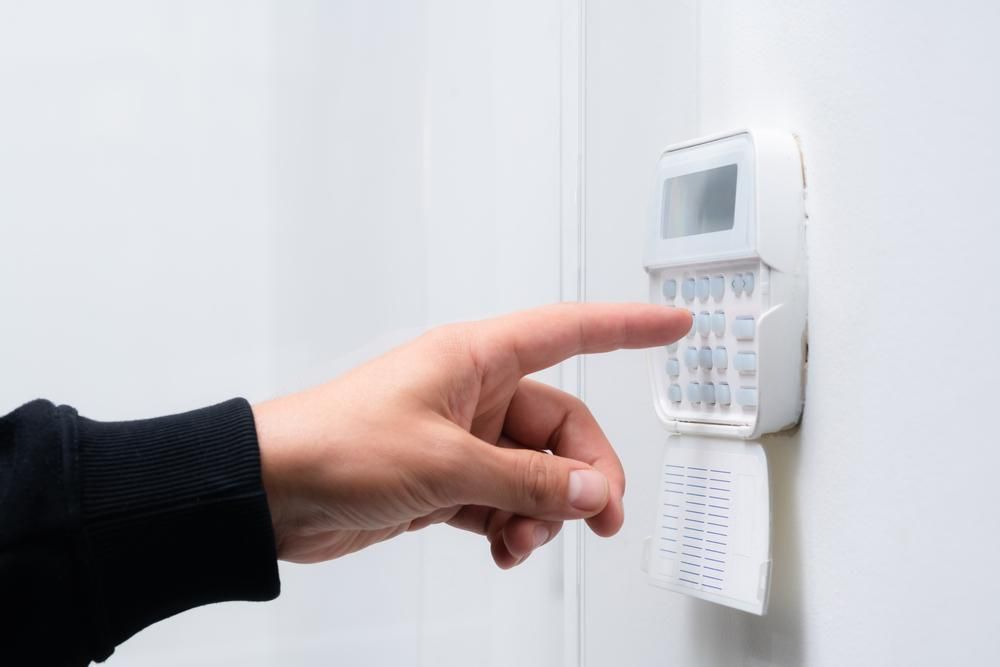 A Person Is Pressing a Button on A Security System — Firewerx In Dubbo, NSW