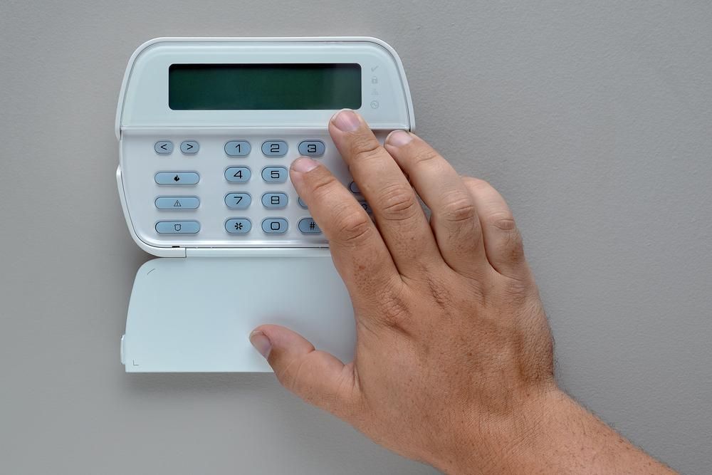 A Person Is Pressing a Button on A Security System — Firewerx In Dubbo, NSW