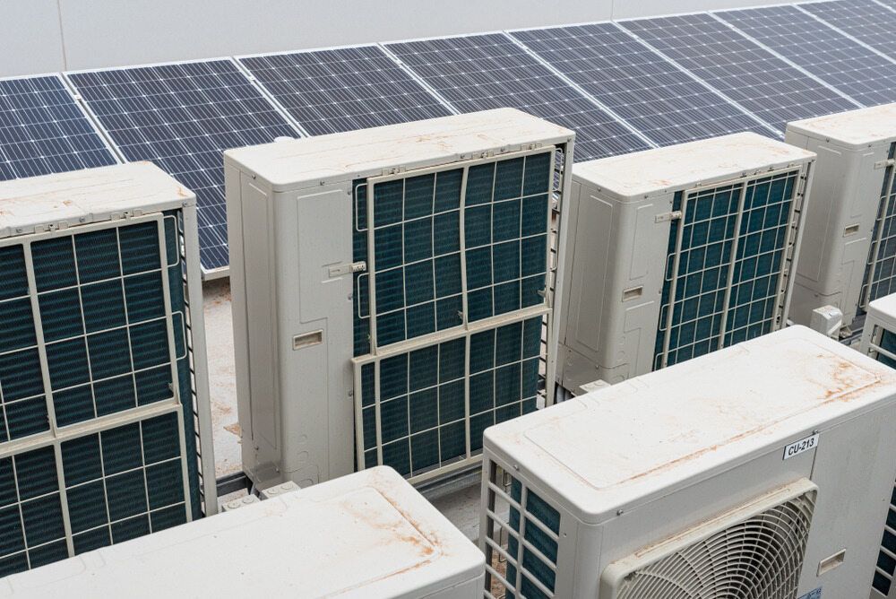 A Row Of Air Conditioners And Solar Panels On The Roof Of A Building — Firewerx In Forbes, NSW